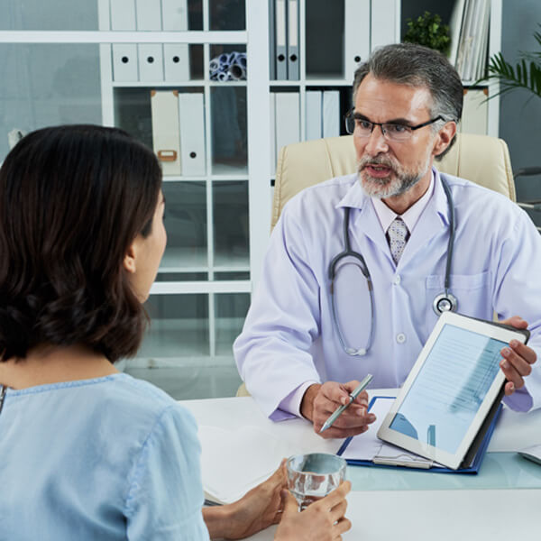medium-shot-middle-aged-doctor-explaining-diagnosis-via-tablet-pc (1)
